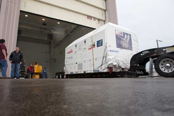 A transporter carries the Orbital ATK Cygnus pressurized cargo module