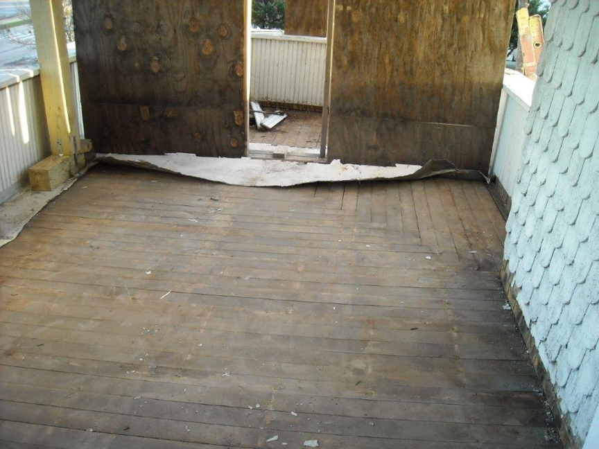 Wood subflooring under metal tiled floor on upstairs porch.